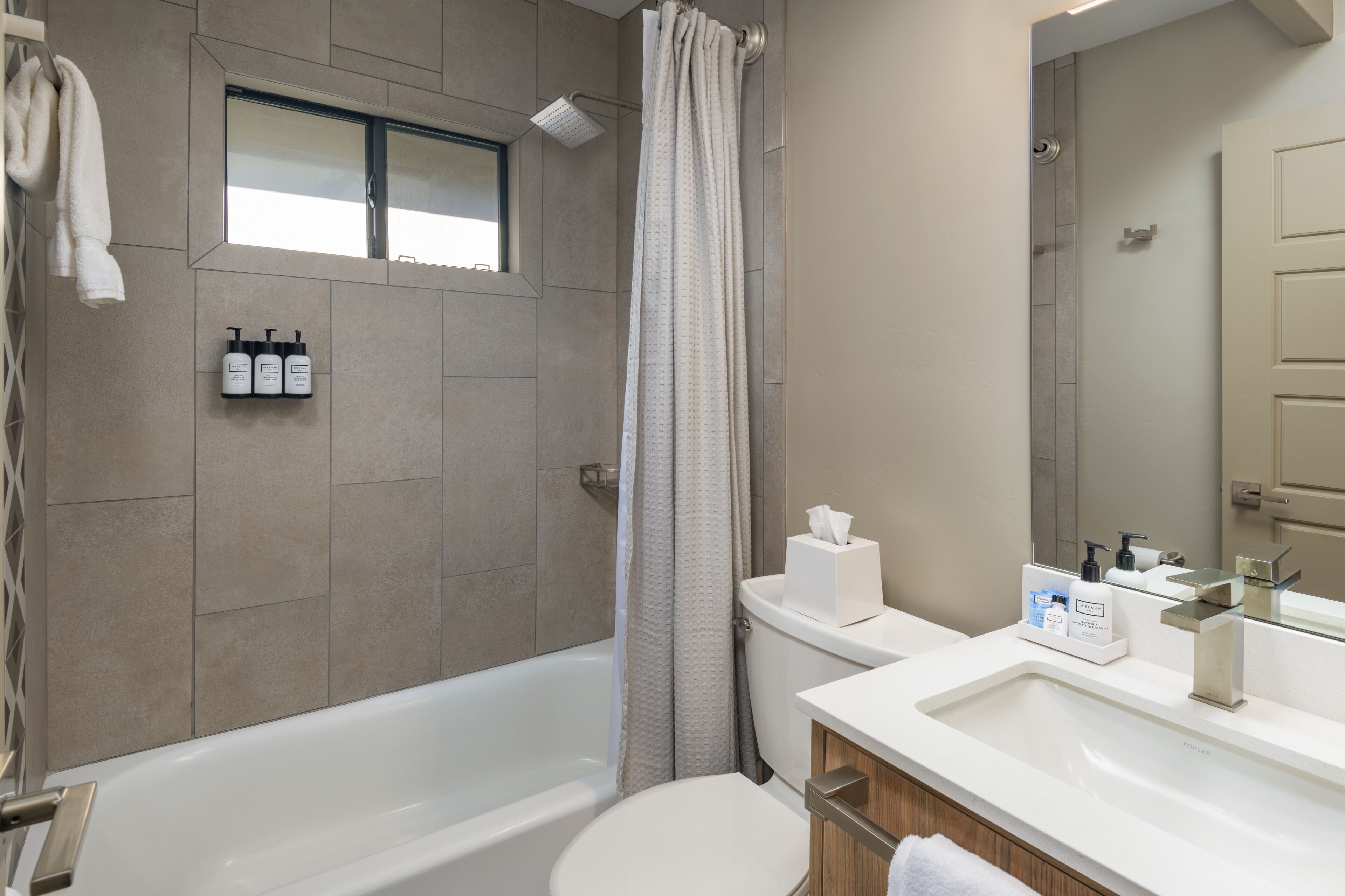 Un baño moderno con bañera, ducha, inodoro y lavamanos.