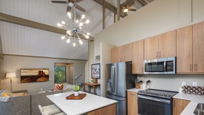 A modern kitchen with stainless steel appliances, wooden cabinets, and a central island. - Matterhorn Inn (Sedona)