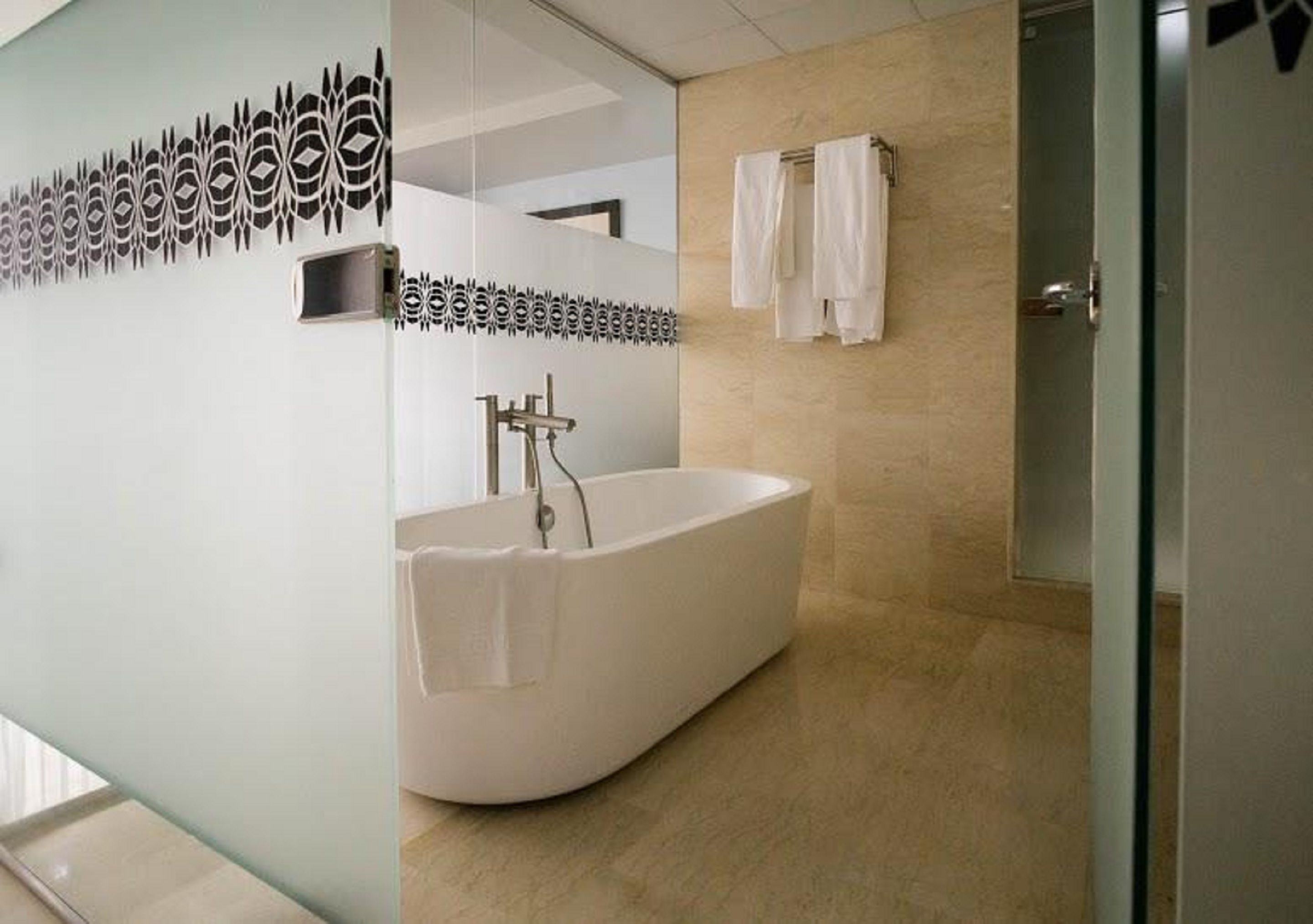 A modern bathroom with a freestanding bathtub, a glass shower enclosure, and a towel rack.