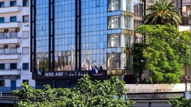 Un hôtel moderne, avec une façade en verre, de nombreux étages et un design original, notamment au niveau des coins du bâtiment.