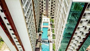 Un edifici alt amb una piscina central envoltada de balcons.