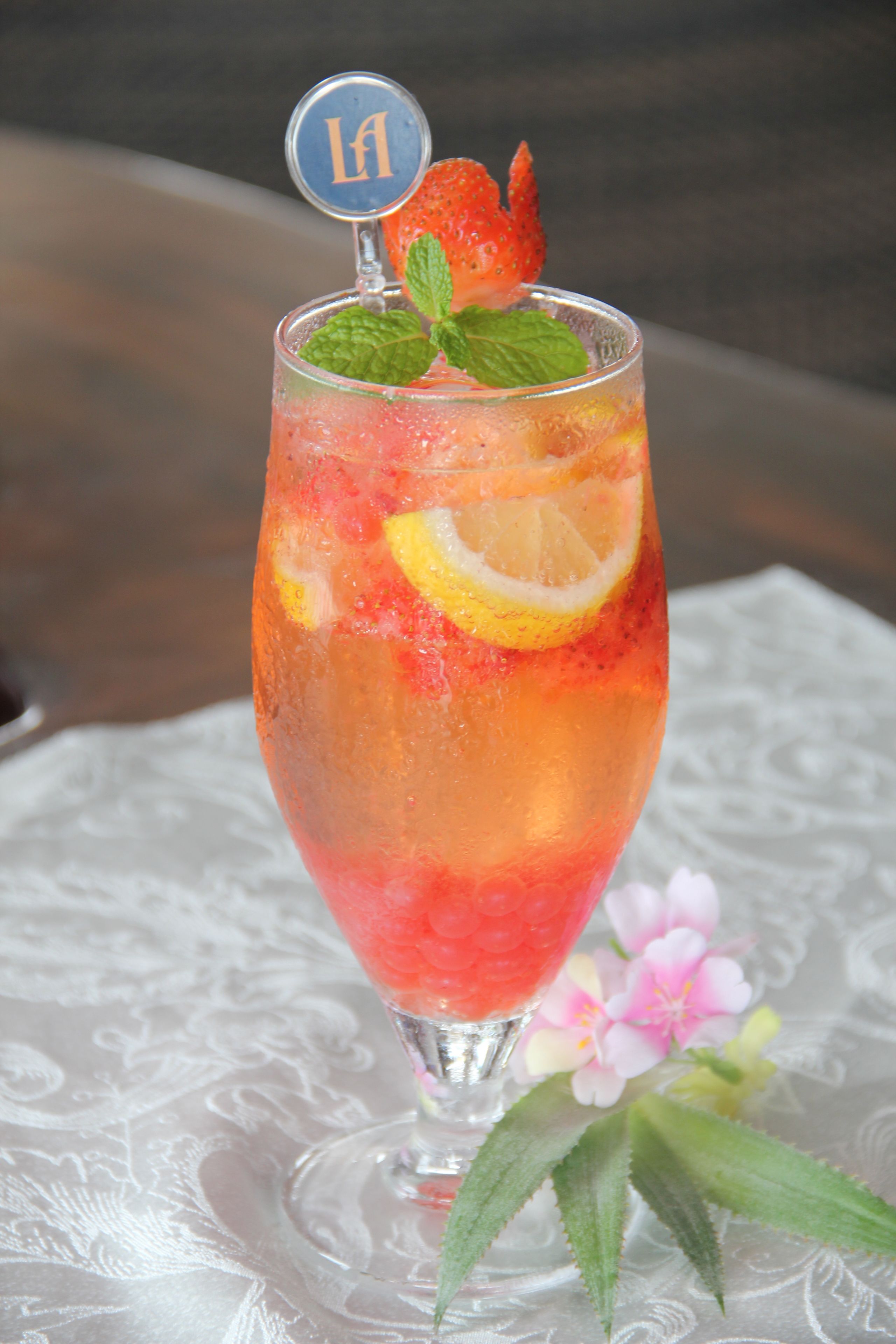 Ein Cocktailglas mit Obstgarnitur auf einem Tisch.