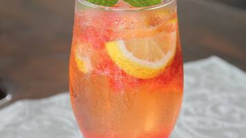 Ein Cocktailglas mit Obstgarnitur auf einem Tisch.