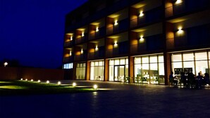 Ein mehrstöckiges Hotel mit beleuchteten Balkonen und großen Fenstern.