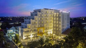 Ein mehrstöckiges Hotel mit beleuchteten Fenstern und einer auffälligen Beschilderung auf dem Dach.