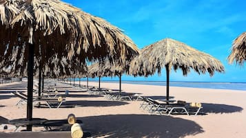 On the beach, white sand, sun-loungers, beach umbrellas
