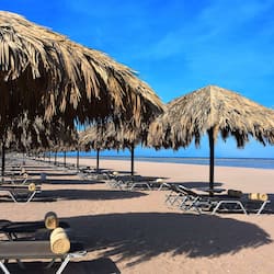 On the beach, white sand, sun loungers, beach umbrellas