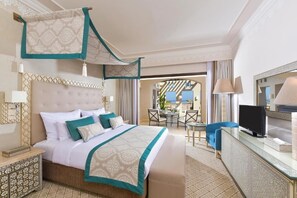A hotel room with a large bed, a desk, a television, and a balcony with a view. - Steigenberger Alcazar (Sharm El Sheikh)