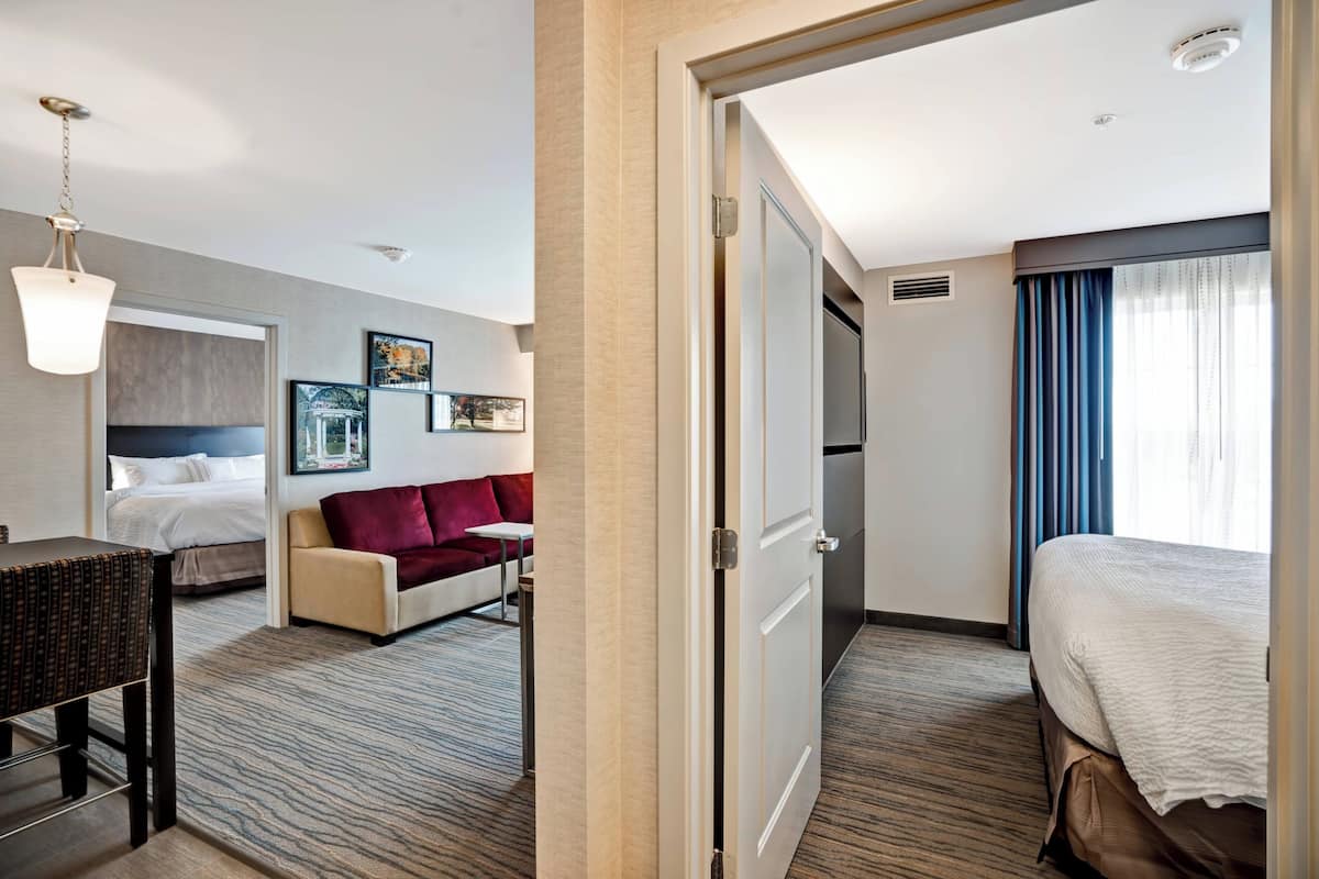 Une chambre d’hôtel avec un lit, un canapé, un bureau et une chaise.