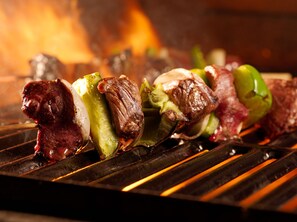 A grill with skewers of meat and vegetables.