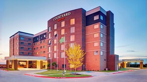 Un hotel Courtyard Marriott con fachada de ladrillo, varios pisos y una entrada central.
