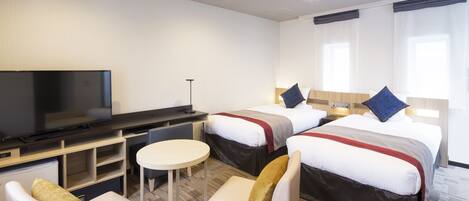A hotel room with two beds, a TV, a desk, and a chair.