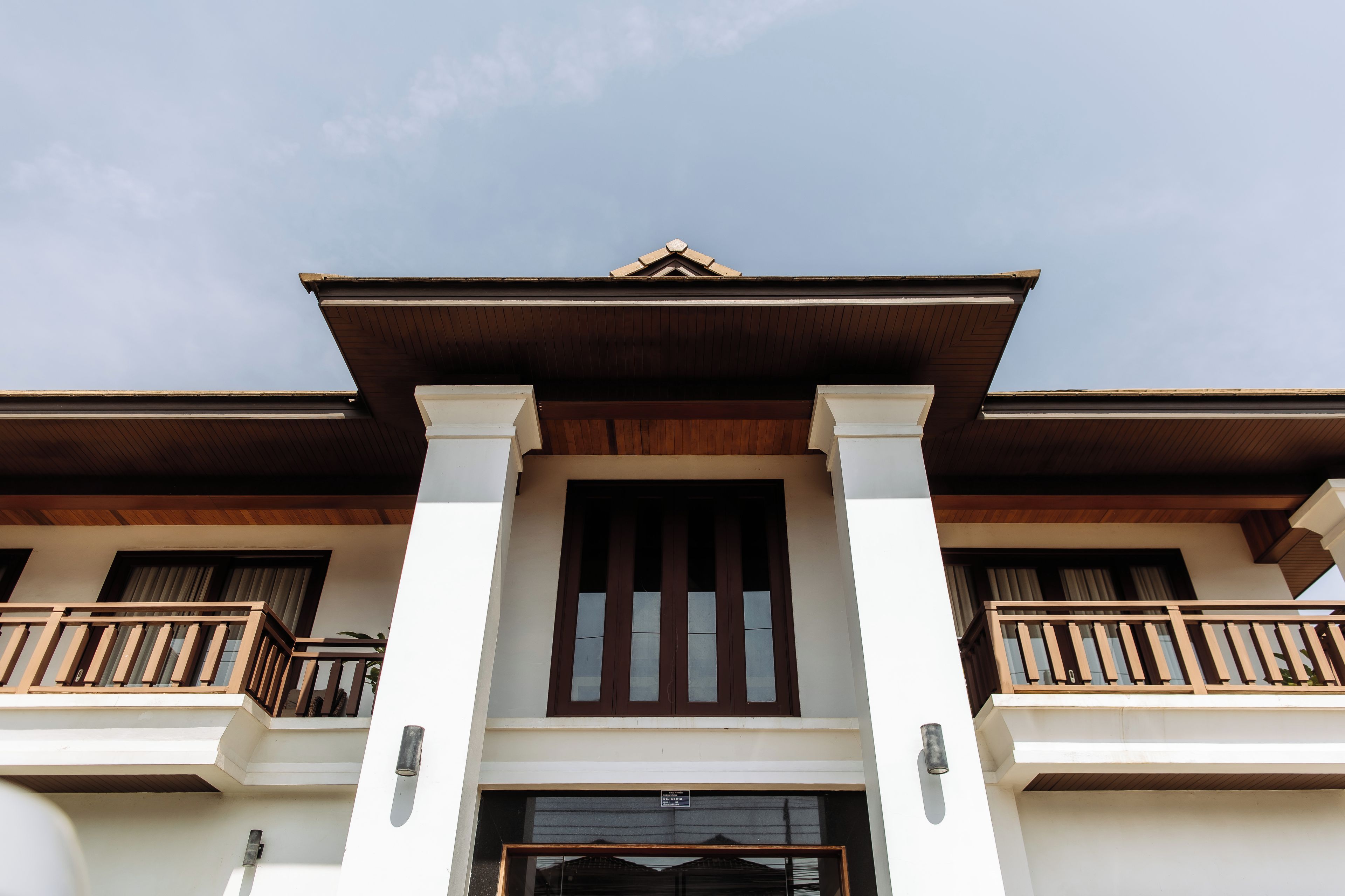 A two-story building with a central entrance, wooden balconies, and a traditional architectural style.