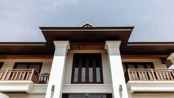 A two-story building with a central entrance, wooden balconies, and a traditional architectural style.