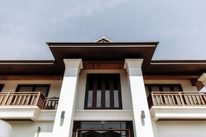 A two-story building with a central entrance, wooden balconies, and a traditional architectural style. - Athena Hotel (Pakse)