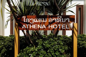 A wooden sign with Thai script and 'ATHENA HOTEL' in English, indicating the hotel's name. - Athena Hotel (Pakse)