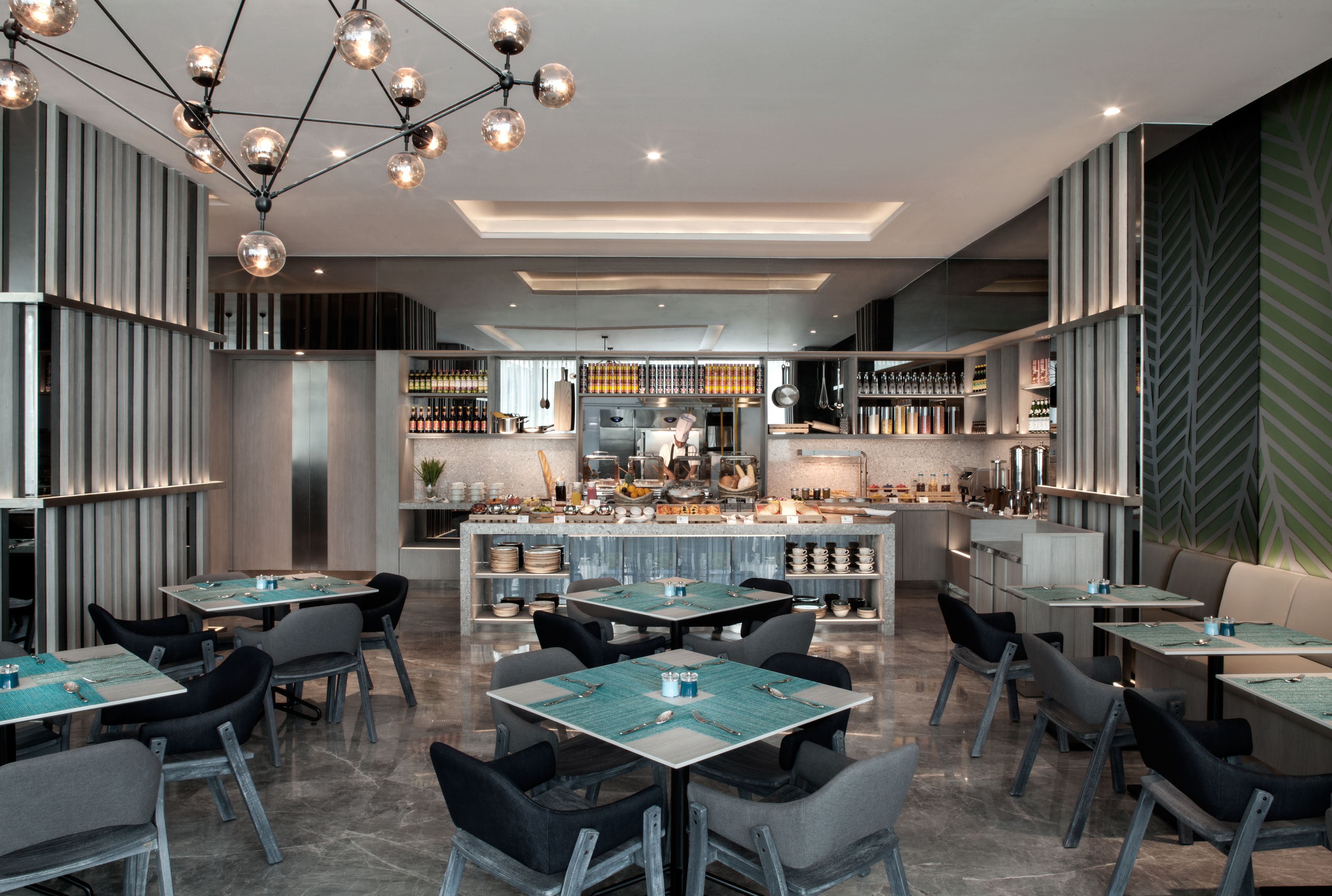 Um restaurante moderno com um bar central, várias mesas de jantar e diversas opções de assento.