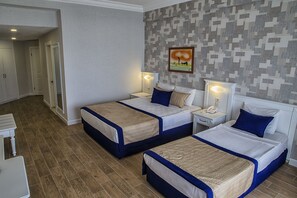 Two single beds with matching headboards and footboards, white linens, and beige throw blankets.