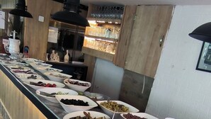 Un bufé con diversos alimentos y utensilios.