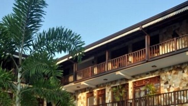 Un hotel con piscina, mobiliario exterior y fachada de piedra.