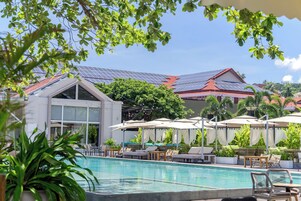 Una piscina al aire libre, camas de piscina gratis, sombrillas