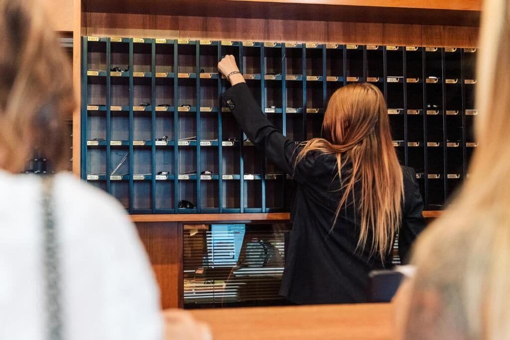 A person reaching for a book from a shelf in a library or bookstore.