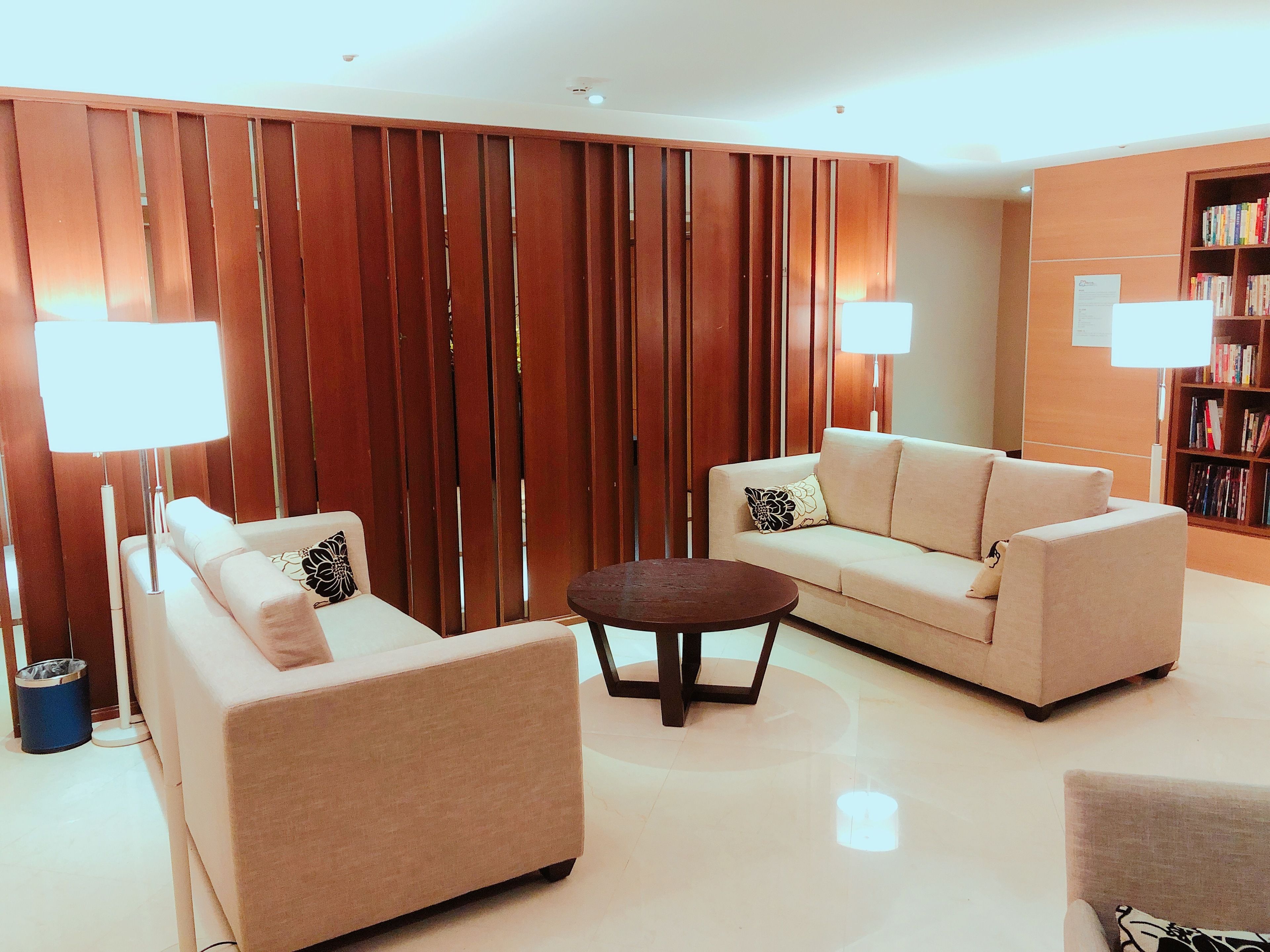 Una sala de estar moderna con sofá, sillón y una pequeña mesa redonda.