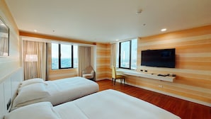 A hotel room with two beds, a TV, a desk, and a chair. - WeMeet Hotel (Pingtung)