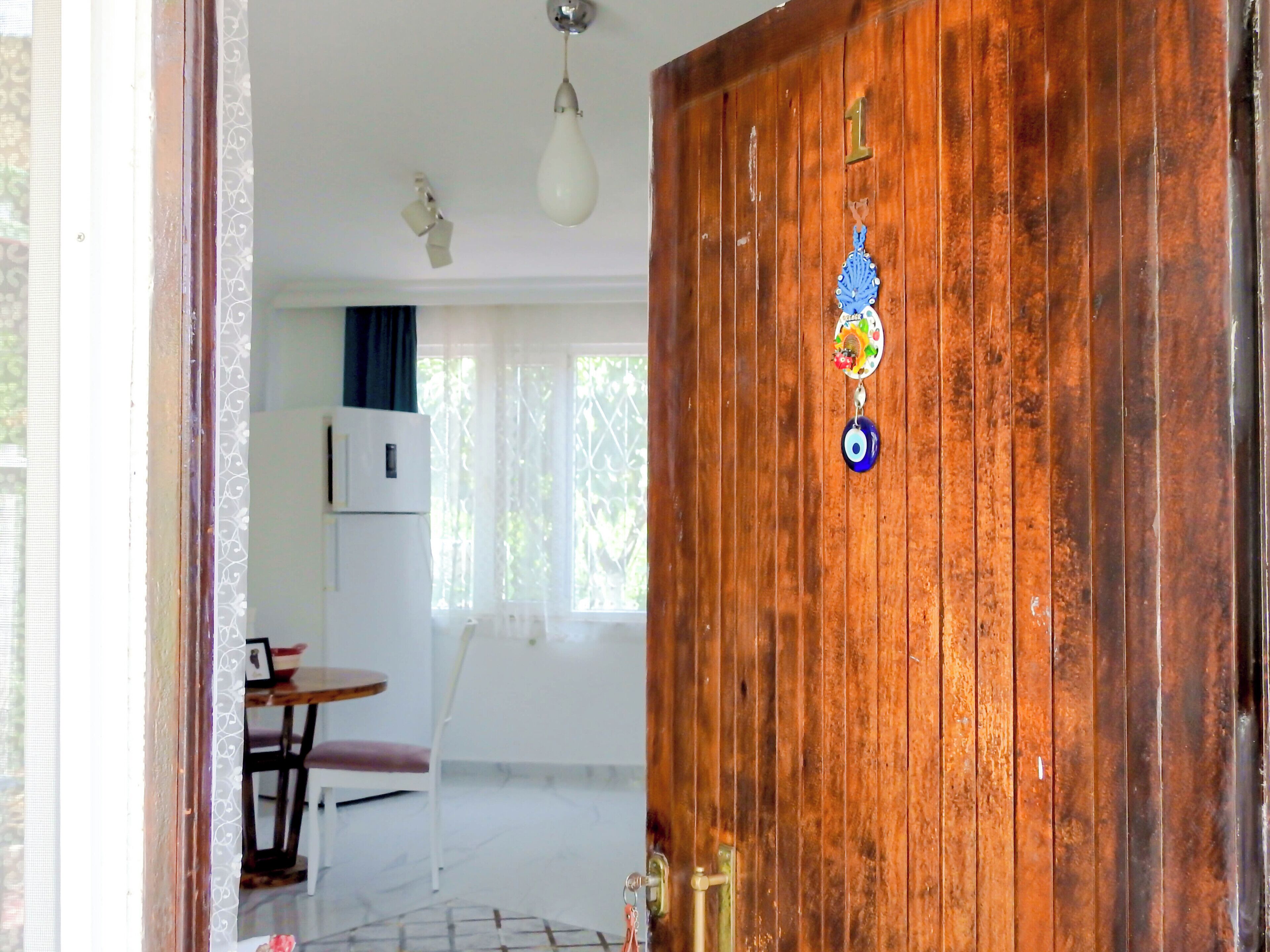 Une porte en bois portant le numéro « 1 » et ornée d’un objet décoratif.
