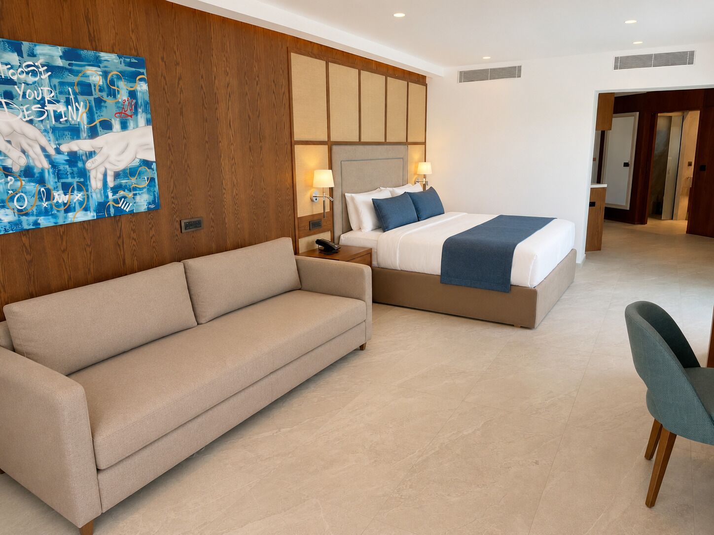 Una moderna camera d'albergo con un divano, un letto, un comodino e un quadro appeso al muro.
