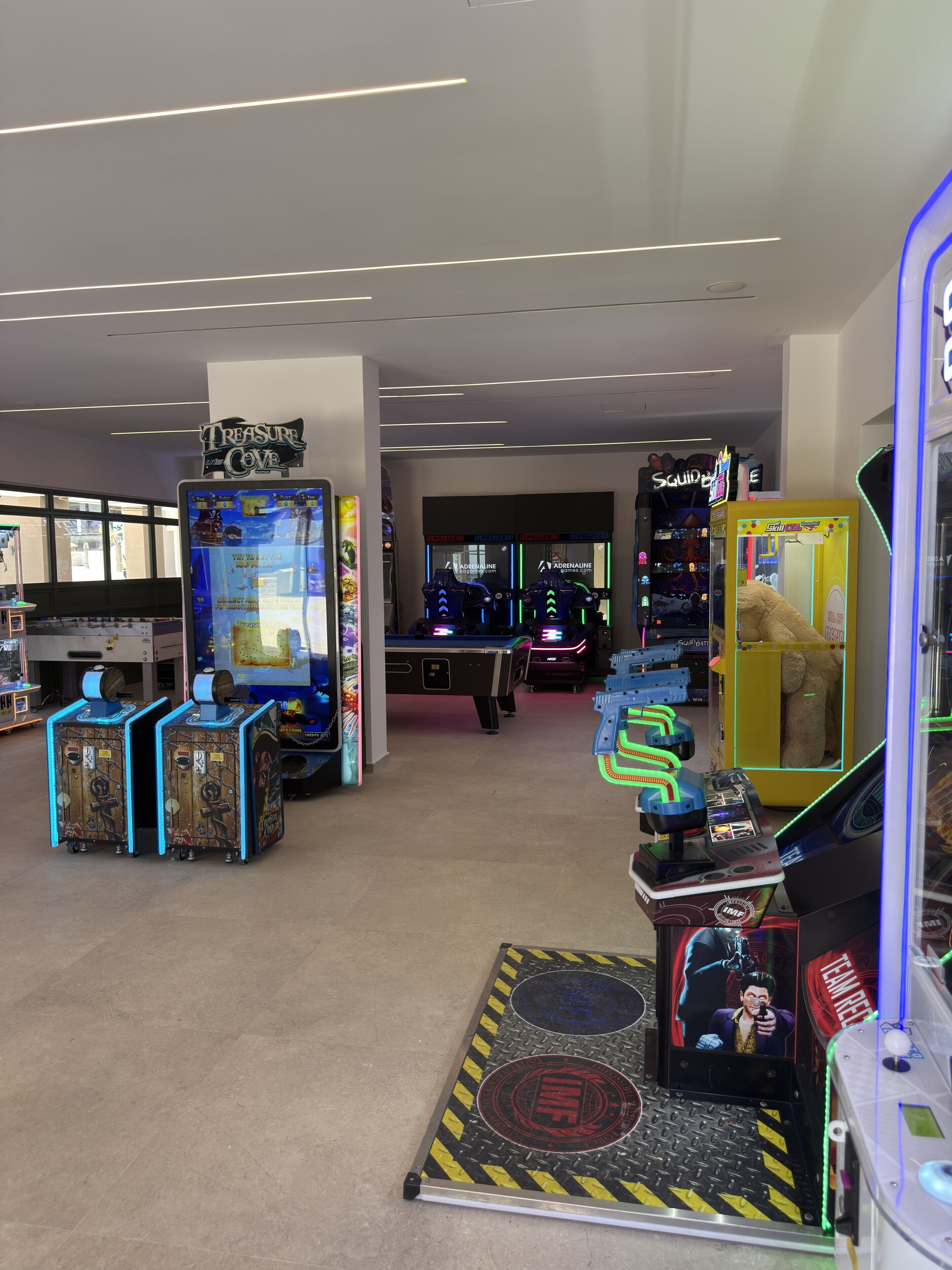 Egy fedett játékterem, ahol különféle játékautomaták találhatók, köztük nyerőgépek és autóverseny-szimulátorok.