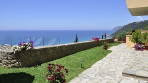 A stone pathway leading to a balcony overlooking a coastal view. - Pelagos Apartments (Corfu)