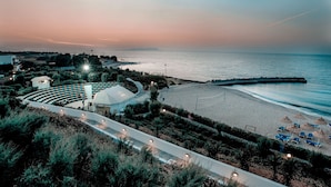 A coastal resort with a beach, a curved pathway, and a large dome structure. - Canvas by Mitsis Cretan Village (Hersonissos)