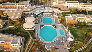 An aerial view of a resort with multiple swimming pools, sun loungers, and a well-maintained garden. - Canvas by Mitsis Cretan Village (Hersonissos)
