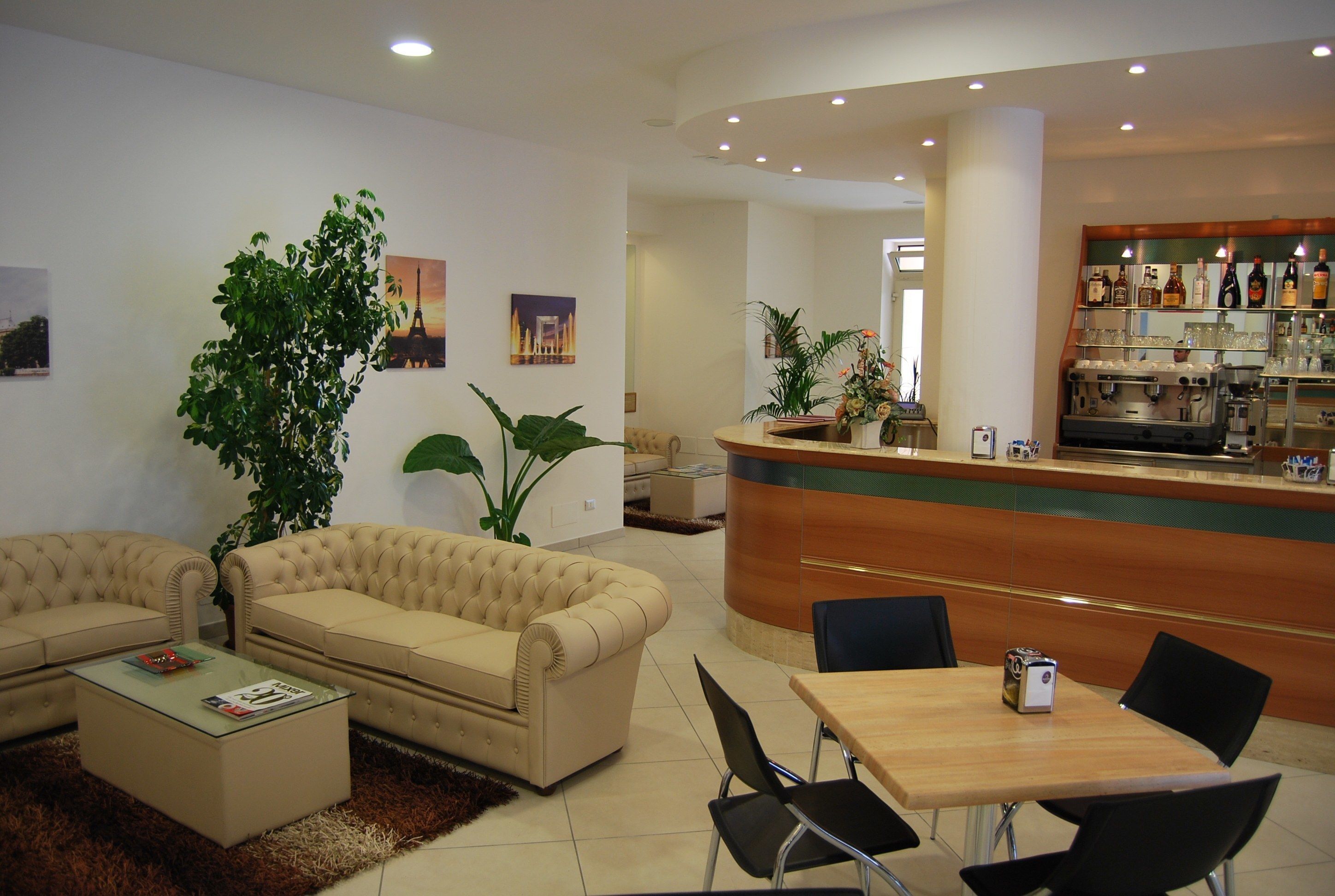 Eine Hotelhalle mit Empfangsschalter, Sitzgelegenheiten und einer Bar.