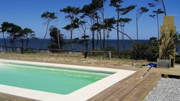 Een seizoensgebonden buitenzwembad, parasols voor strand/zwembad