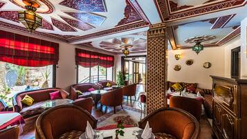 Un ristorante con soffitti a motivi rossi e bianchi, arredi in legno e vista sull'esterno.