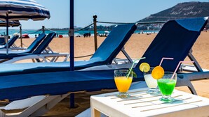 A beach scene with lounge chairs and a table with drinks. - Atlantic Hotel Agadir (Agadir)