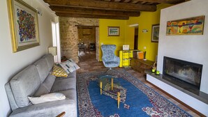 Ein Wohnzimmer mit einer Couch, einem blauen Teppich, einem Kamin und einer Steinwand.