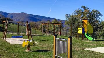Un'area giochi all'aperto con altalene, scivoli e strutture per arrampicata.