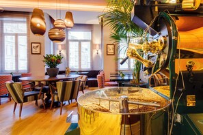 A modern interior with a coffee roasting machine, wooden flooring, and striped upholstered chairs. - Ravouna 1906 Suites - Special Class, Adults Only (Istanbul)