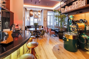 Een moderne bar met een koffieapparaat, zitplaatsen en een grote koffiemolen.