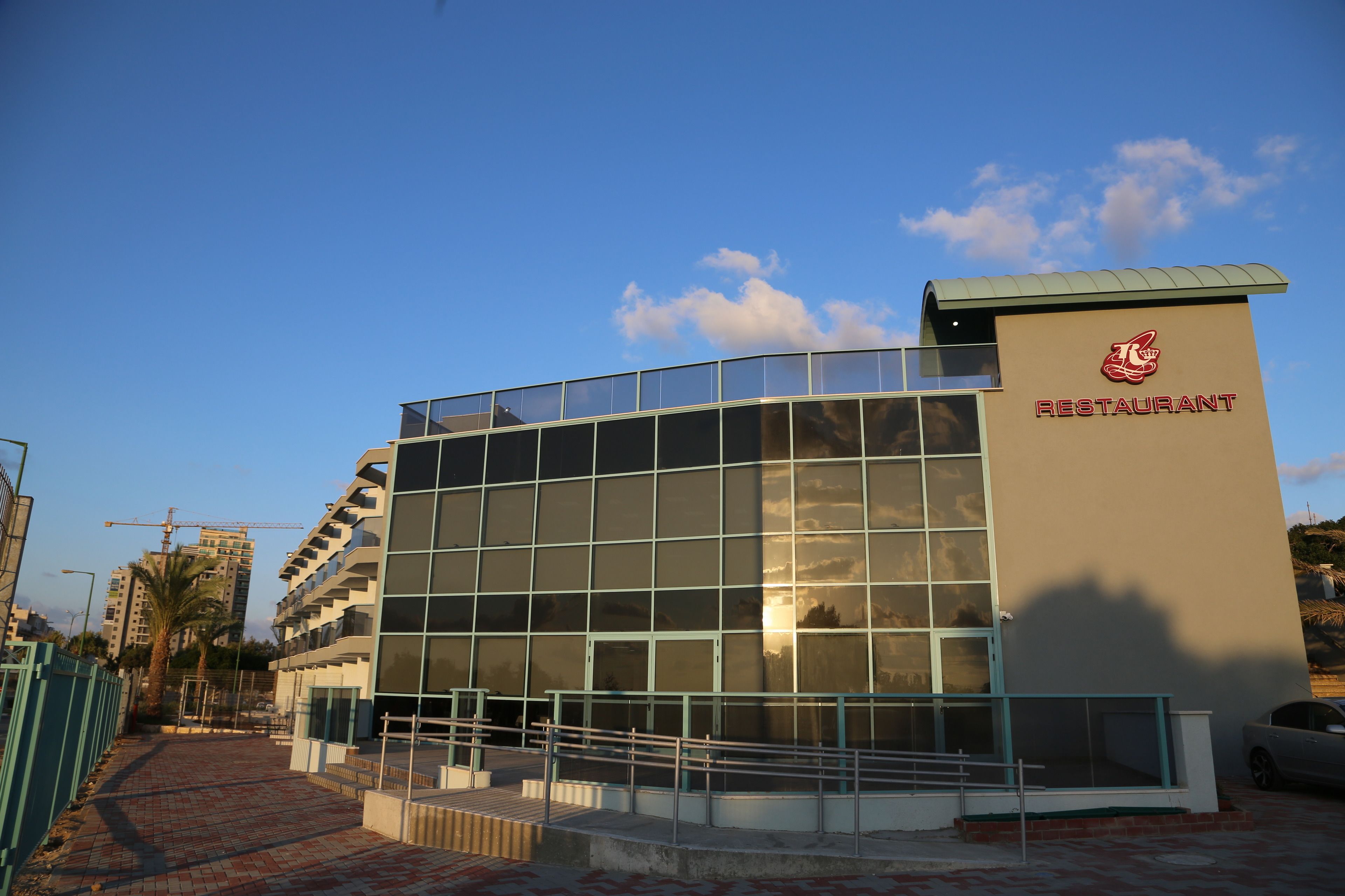 A modern building with a glass facade and a sign that reads "RESTAURANT".