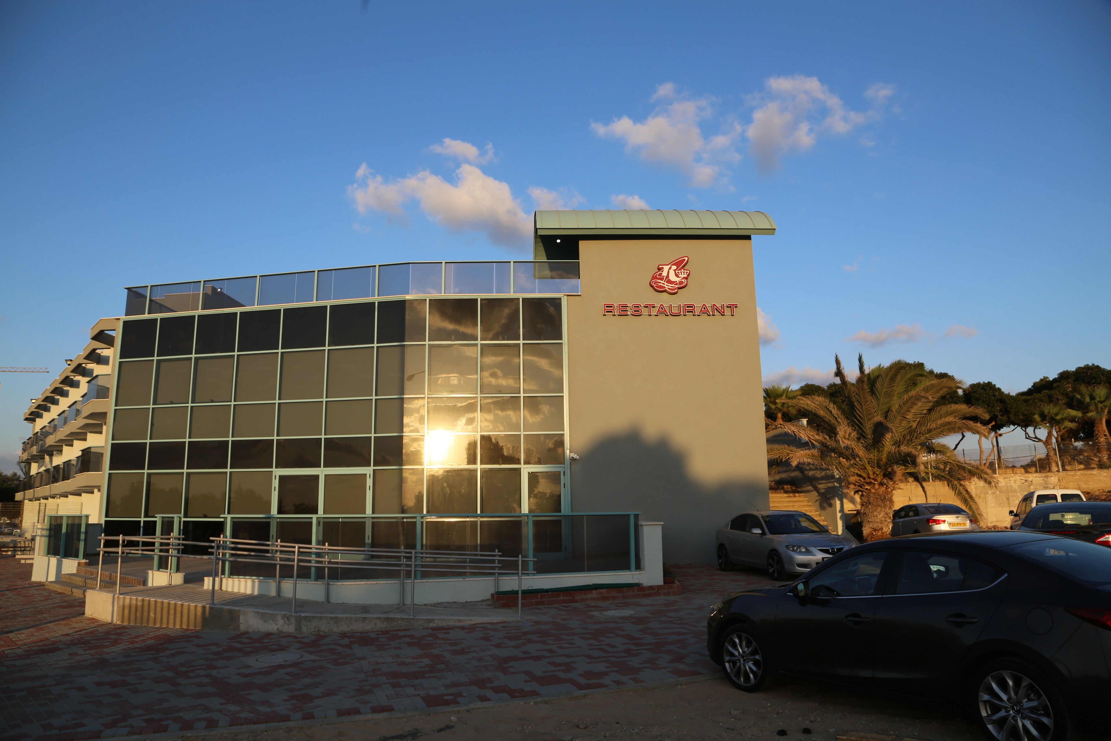 A modern building with a glass facade and a sign that reads "RESTAURANT".
