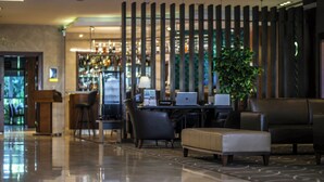 A modern lobby with a bar area, seating, and a reception desk. - Doubletree by Hilton Izmir Karsiyaka (Izmir)