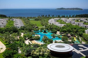 Un resort con villas modernas, una piscina central y vistas al mar.