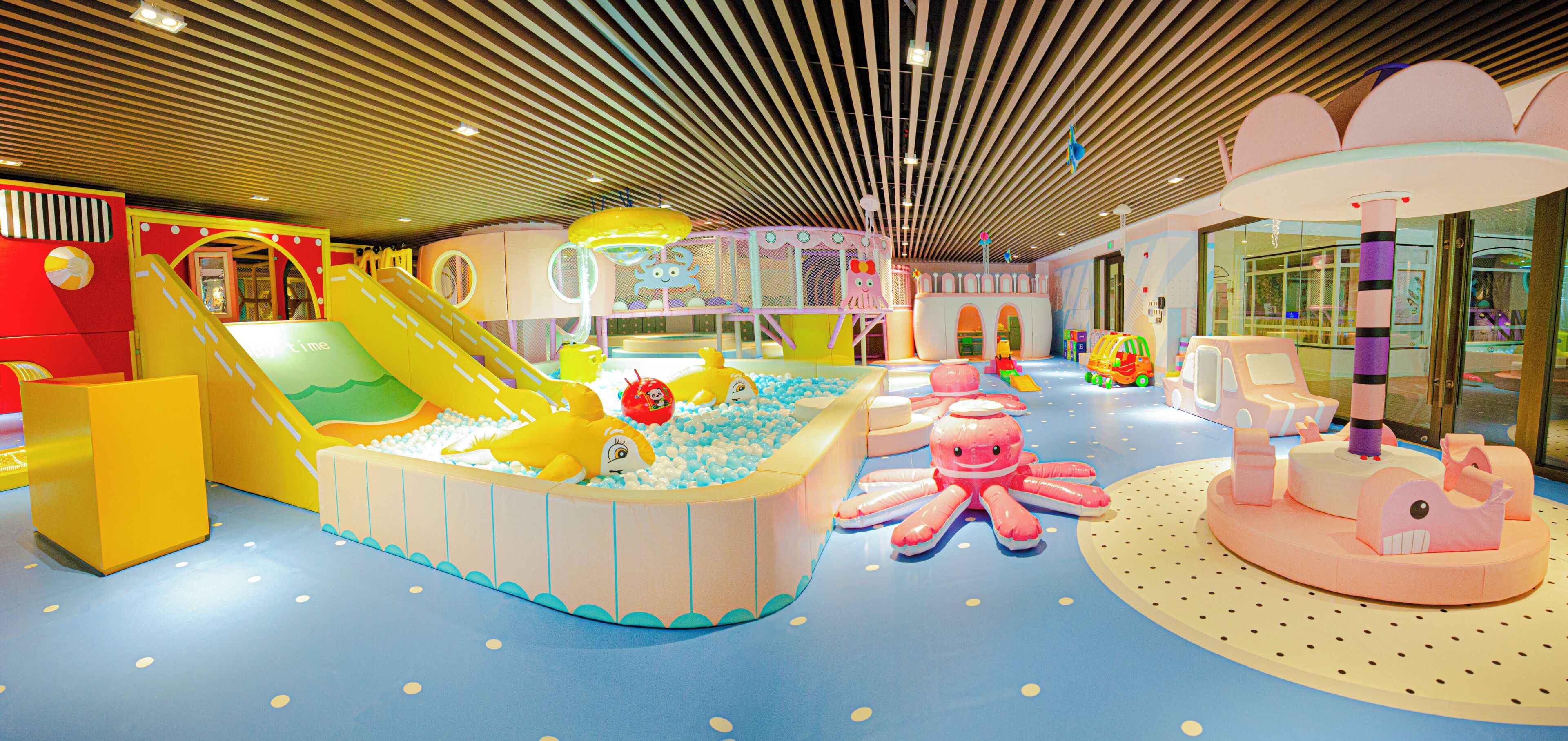 An indoor play area with slides, ball pits, and various play structures.