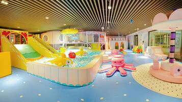 An indoor play area with slides, ball pits, and various play structures.