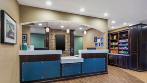 A reception area with a stone accent wall, a counter with a blue patterned design, and a snack bar with various packaged goods.