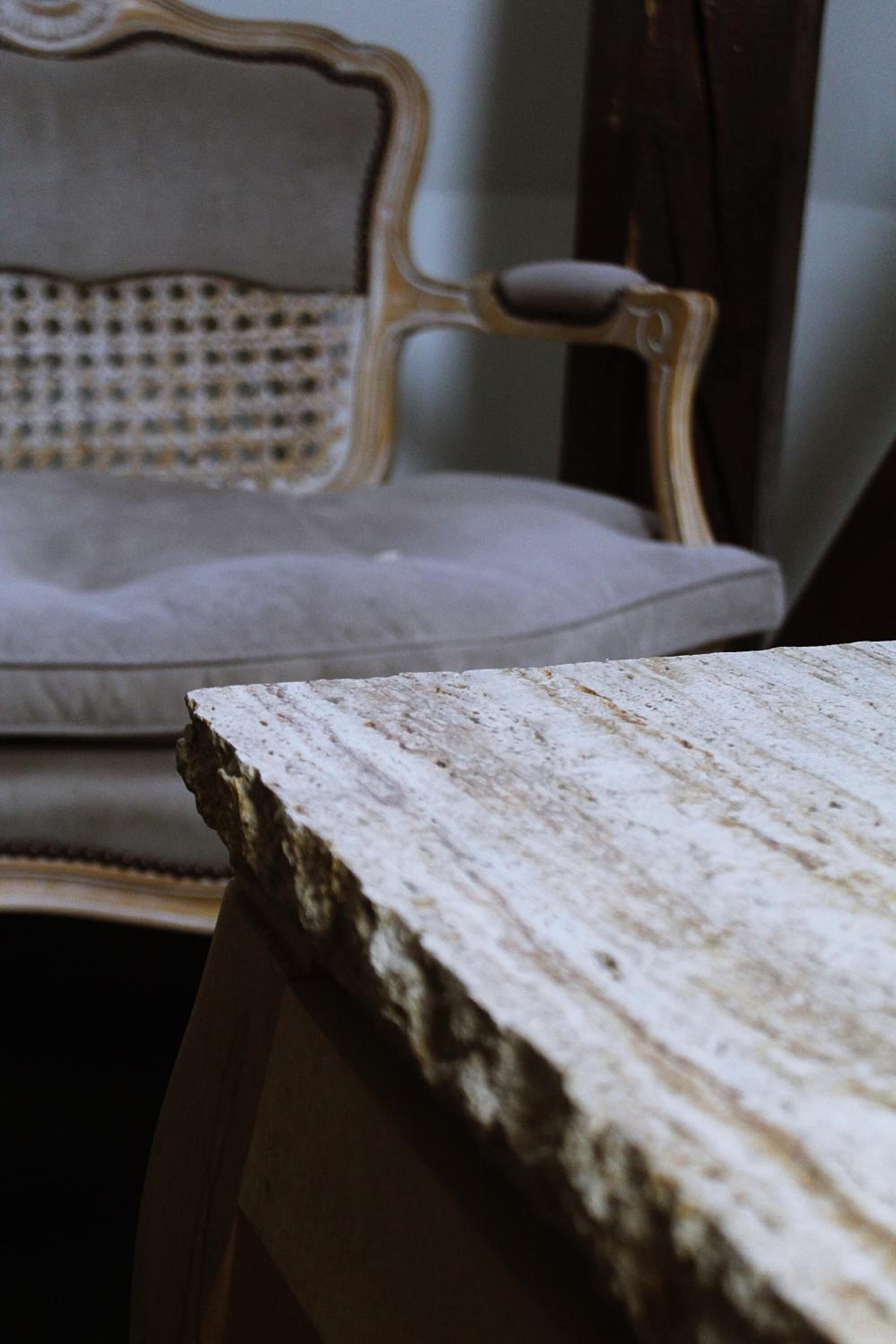 Primer plano de una superficie de mármol con una silla al fondo.